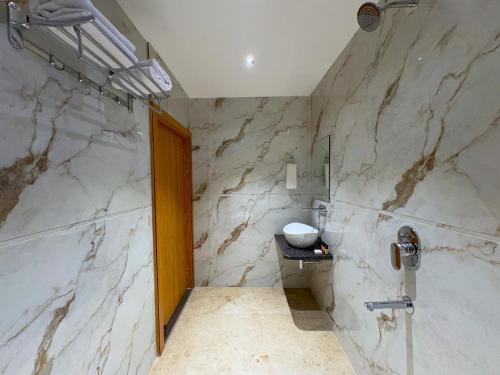 a marble bathroom with a sink and a shower at Hotel Kunadan Courtyard in Gwalior