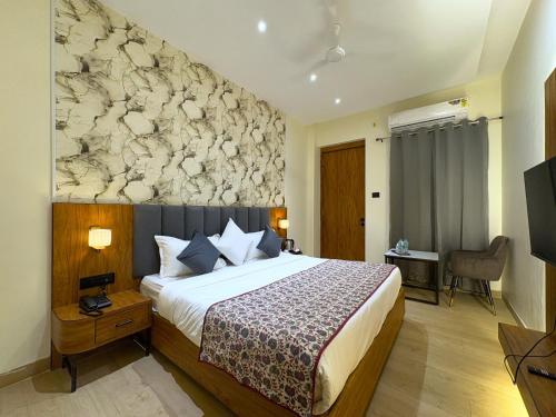 a hotel room with a bed and a stone wall at Hotel Kunadan Courtyard in Gwalior
