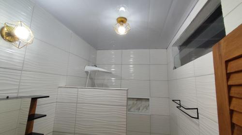 a bathroom with a shower with two lights on the ceiling at Pousada Solar Encanto do Marajó in Soure