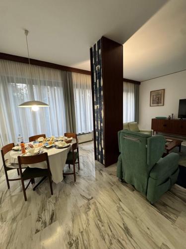 ein Wohnzimmer mit Tisch und Stühlen und ein Esszimmer in der Unterkunft La Grande Casa di Malpensa - B&B in Gallarate