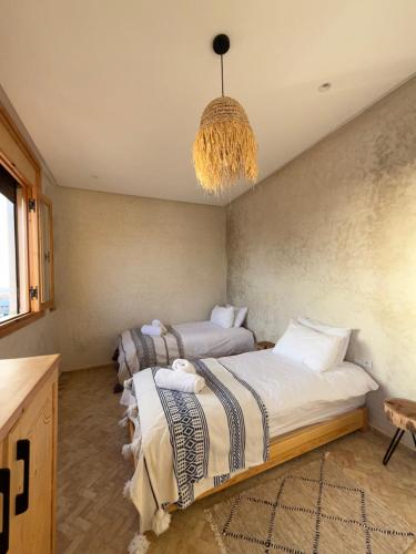 En eller flere senge i et værelse på Numidia Surf House