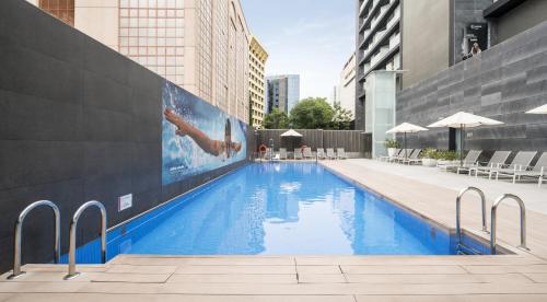 una piscina con un gran mural en el lateral de un edificio en Ilunion Atrium en Madrid