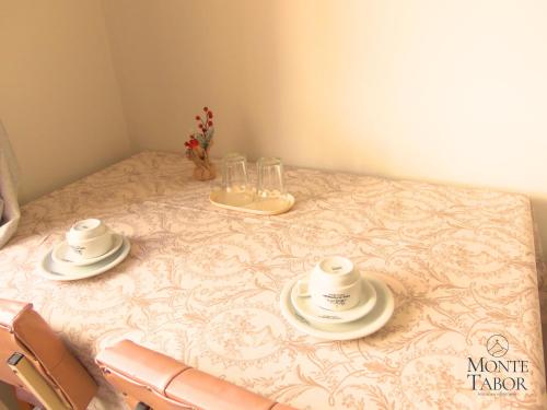 einen Tisch mit zwei Tassen und Untertassen darauf in der Unterkunft Pousada & Hospedaria Monte Tabor in Francisco Beltrão