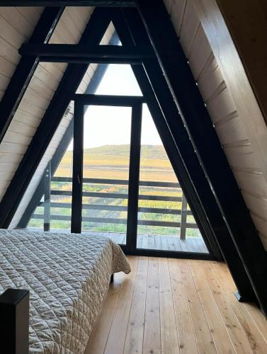 a bedroom with a bed and a large window at Hill House in Slobozia-Măgura