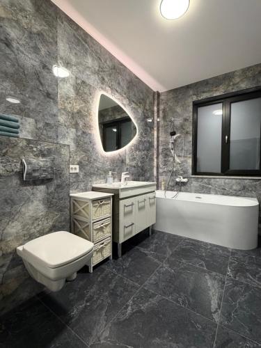 een badkamer met toilet, bad en wastafel bij Altheda Living Stejari 4B in Suceava