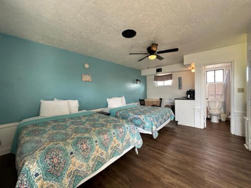 a bedroom with two beds and a ceiling fan at Nautical Motel in Hampton