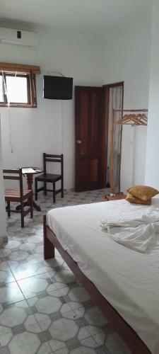 a bedroom with a bed and a table and chairs at Micaval Residential in São Tomé