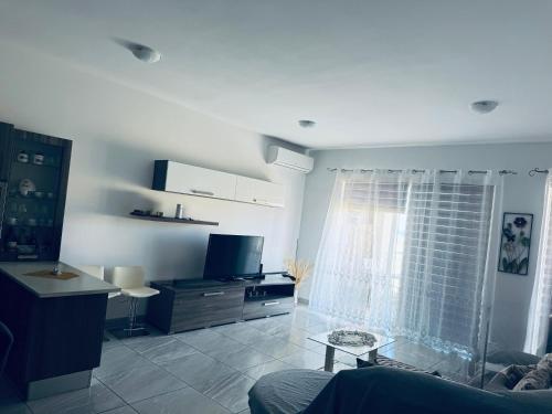a living room with a couch and a television at Private Double bedroom In Marsaskala2 in Il-Ħamrija