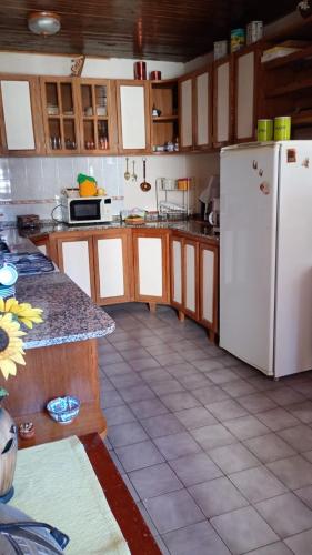 una cucina con frigorifero bianco e pavimento piastrellato di Alojamiento en Malargue a Malargüe