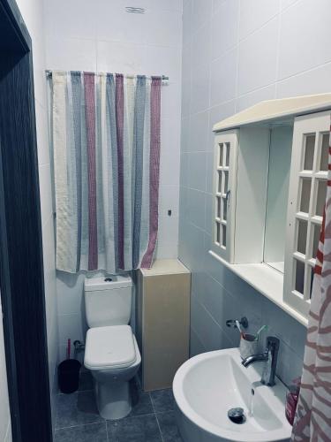 a bathroom with a toilet and a sink at Private Double bedroom In Marsaskala2 in Il-Ħamrija