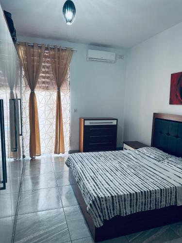 a bedroom with a bed and a large window at Private Double bedroom In Marsaskala2 in Il-Ħamrija