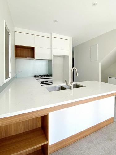 a kitchen with white cabinets and a sink at Standalone Home Near Bruce Pulman Park 5BR 3 Baths in Auckland