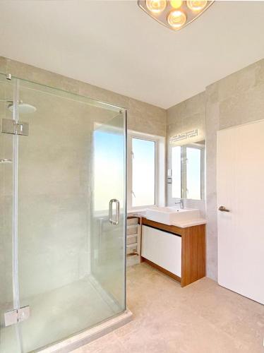 a bathroom with a shower and a sink at Standalone Home Near Bruce Pulman Park 5BR 3 Baths in Auckland