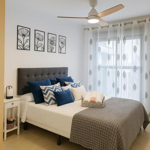 a bedroom with a bed with blue and white pillows at Tu Lugar Soñado-Lifestyle Premium Pool-Confort in Sant Jordi