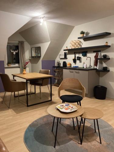 een woonkamer met tafels en stoelen en een keuken bij Appartementen Elzentuin in Oud-Beijerland