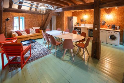 a kitchen and living room with a table and chairs at Gîte insolite in Nuits-Saint-Georges