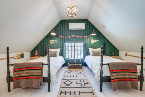 two beds in a attic bedroom with green walls at Charming Jaffrey Cottage with Deck and Grill! in Jaffrey