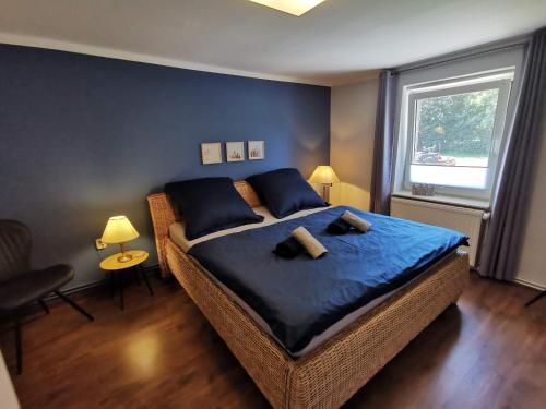 een slaapkamer met een bed met blauwe lakens en een raam bij 07 Birkenhain - Hof Wiesengrund in Parchtitz