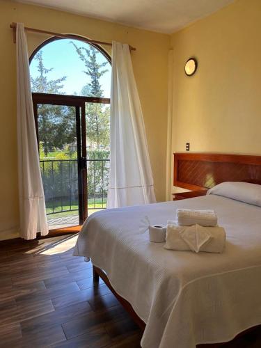 a bedroom with a bed and a large window at HOTEL RESTAURANT LOS PRISMAS in Huasca de Ocampo