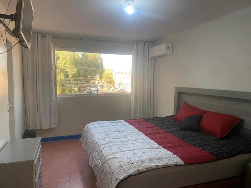 a bedroom with a large bed with a window at Habitación Céntrica in San Luis Potosí