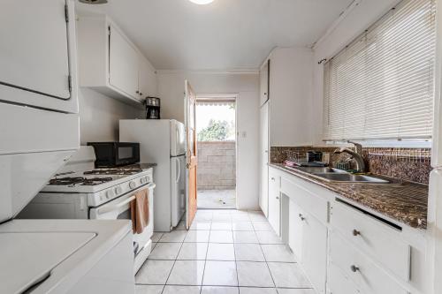 a kitchen with white cabinets and a white refrigerator at Spacious Single Apt D In Santa Monica in Los Angeles