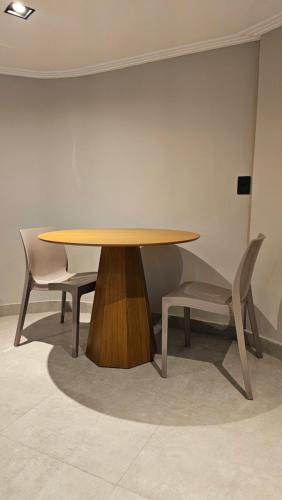 - une table en bois et 2 chaises dans une chambre dans l'établissement Chalés Feliz Boipeba, à Cairu