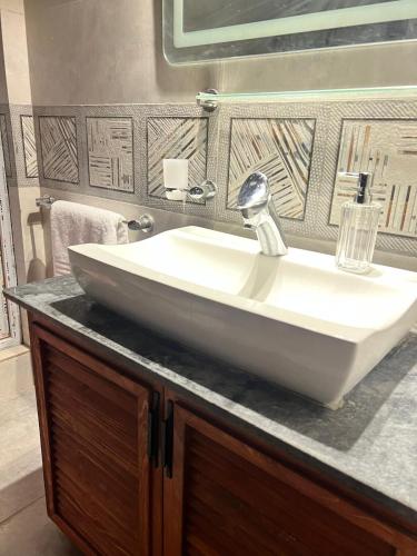 a white sink on a counter in a bathroom at Haven Mushkpuri Terraces Khaira Gali - 3BR Home, Lawn, BBQ & Fireplace in Chhāngla Gali