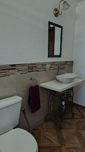 ein Badezimmer mit Toilette, Waschbecken und Spiegel in der Unterkunft Casa a 500 metros del Mar in Quequén