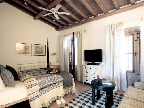 a bedroom with a bed and a flat screen tv at Apokryfo Traditional Guesthouse in Lofou