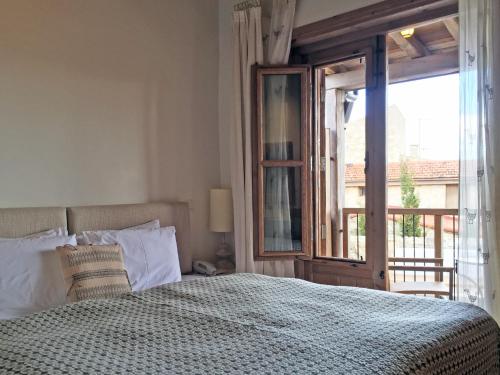 a bedroom with a bed and a large window at Apokryfo Traditional Guesthouse in Lofou