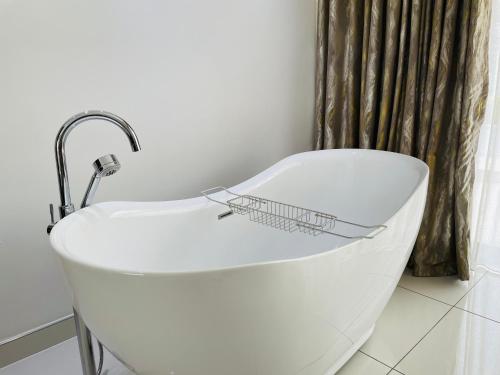 een witte badkuip met daarop een mandje bij Loreho boutique in Mahikeng