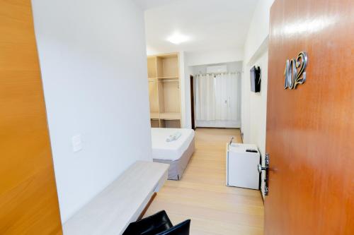 a room with a couch and a bed and a door at Hotel & Restaurante Paraíso Ponte Nova - Ponte Nova - MG in Ponte Nova
