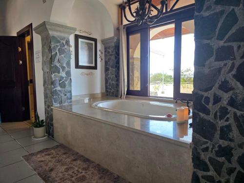 a large bath tub in a room with a window at Casona Cocobolo el mejor lugar de Costa Rica in Guanacaste