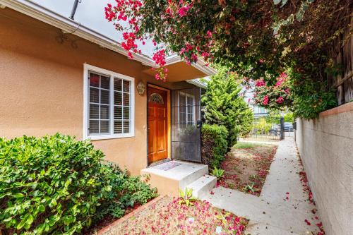 a house with a porch and a door with pink flowers at Spacious Two Bedroom in Santa Monica #E in Los Angeles