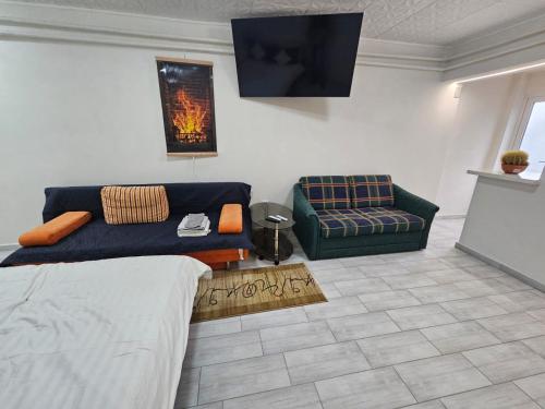 a living room with a couch and a chair at BOMBA Apartman in Târgu Secuiesc