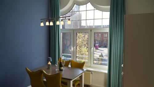 a dining room with a table and a window at Eicher Ferienwohnungen Warnemünde in Warnemünde