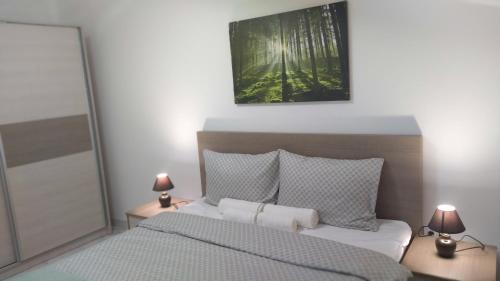 a bedroom with a bed and two lamps on tables at Sokobanja Apartmani in Soko Banja