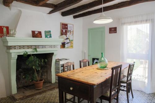 ein Esszimmer mit Tisch und Kamin in der Unterkunft Cal Teixidor in Mediona