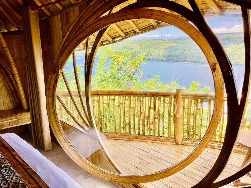 een rond houten balkon met uitzicht op een meer bij Les Terrasses Ceningan in Nusa Lembongan