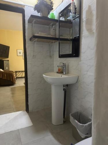 a bathroom with a white sink and a mirror at Ô bien être in Saint-Louis