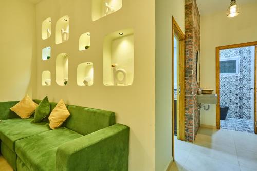 een groene bank in een woonkamer met een badkamer bij Dar Charkaoui in Tetouan
