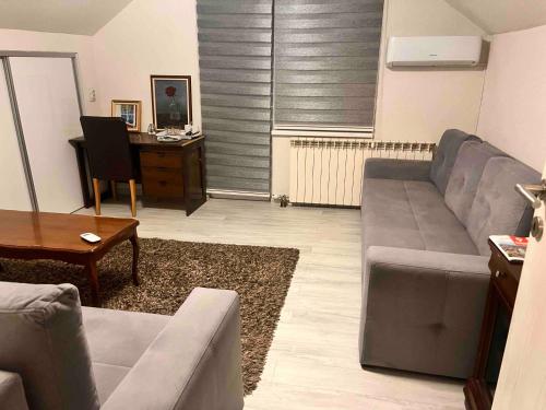 a living room with a couch and a desk at Apartman Sunce in Sarajevo