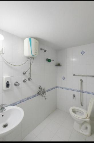 a white bathroom with a toilet and a sink at Family Home 2BHK Apartment Thane West in Thane
