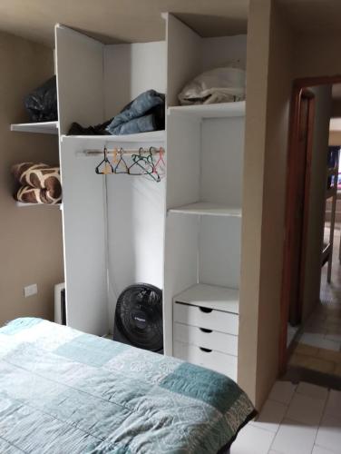 a bedroom with a bed and white cabinets and shelves at Depto TOMY in Mar de Ajó