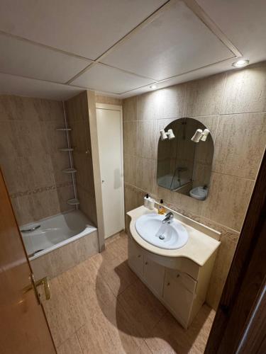 ein Badezimmer mit Waschbecken, Spiegel und Badewanne in der Unterkunft Especial Apartamento Valencia in Valencia