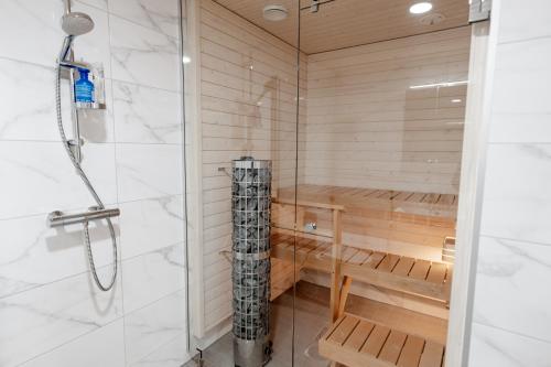 a sauna with a shower and a wooden bench at Snowflake Suites VIII with private sauna in Rovaniemi