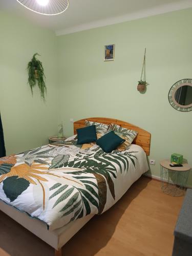 a bedroom with a bed with a comforter on it at La clef du ban in Ban-sur-Meurthe-Clefcy