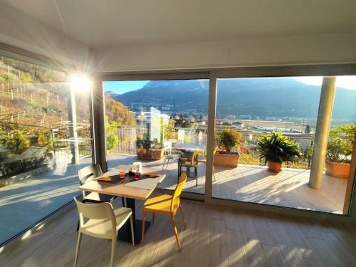 una sala da pranzo con tavolo e sedie su un balcone di Agritur Gasadòr a Trento