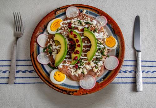 a plate of food with eggs and avocado on it at Hotel Zandoyo Bed & Breakfast in Puerto Escondido