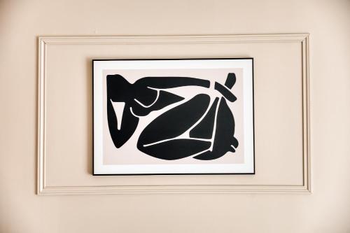 een ingelijst schilderij van een vrouw aan een muur bij Appartement 39m2 - Free Parking - Rer C - Métro 13-14 - Ascenseur - Easy Check in - in Asnières-sur-Seine